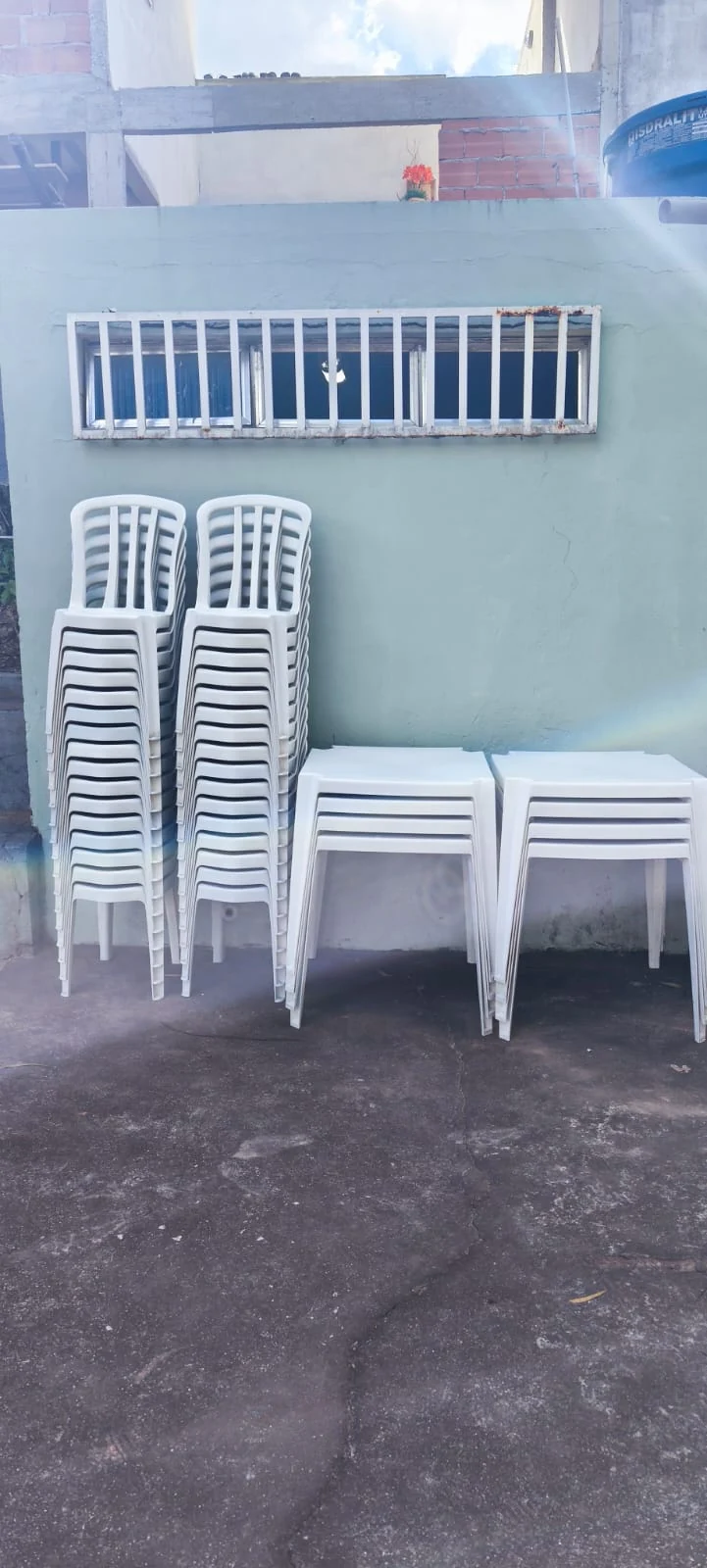 Cadeiras e mesas plásticas empilhadas no estoque em Taquara
