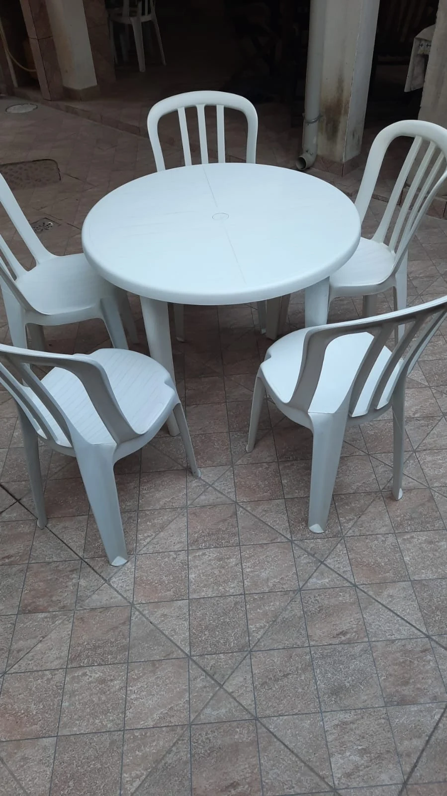 Mesa redonda plástica com quatro cadeiras montadas em Taquara