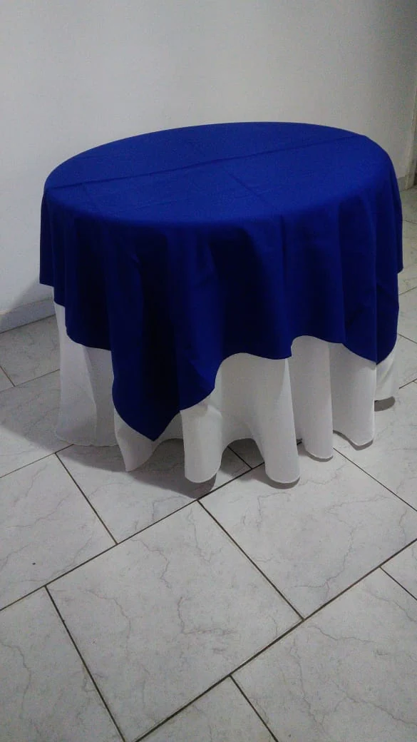 Mesa redonda com toalha azul montada para festa em Taquara