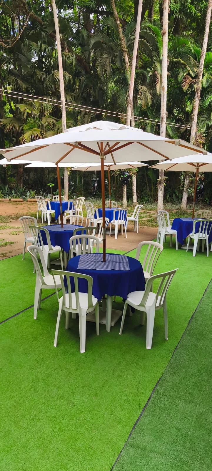 Ombrelones com mesas e cadeiras montados para evento em Taquara